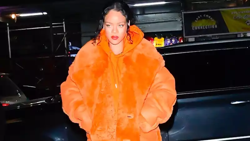 Rihanna shines in a bright orange coat at Sephora, NY