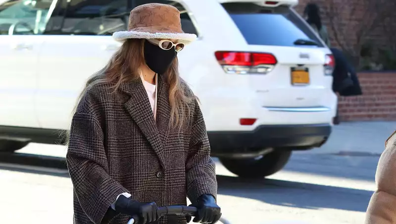 Gigi Hadid walks with her daughter in a Mango coat and designer accessories.