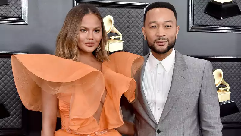 Chrissy Teigen reveals her baby belly after announcing her third child pregnancy.