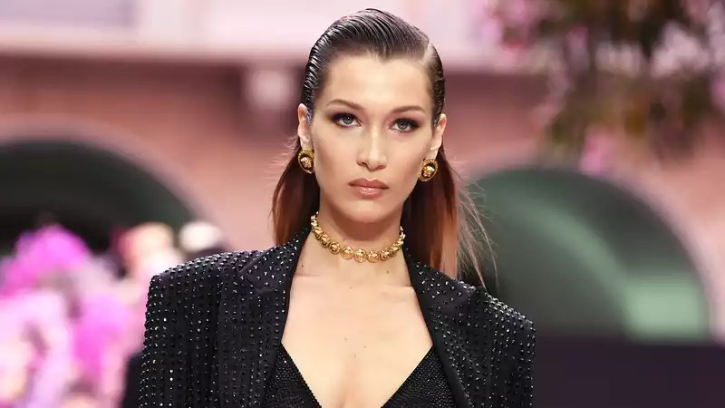 Bella Hadid poses topless with a burrito in hand to distance herself from society