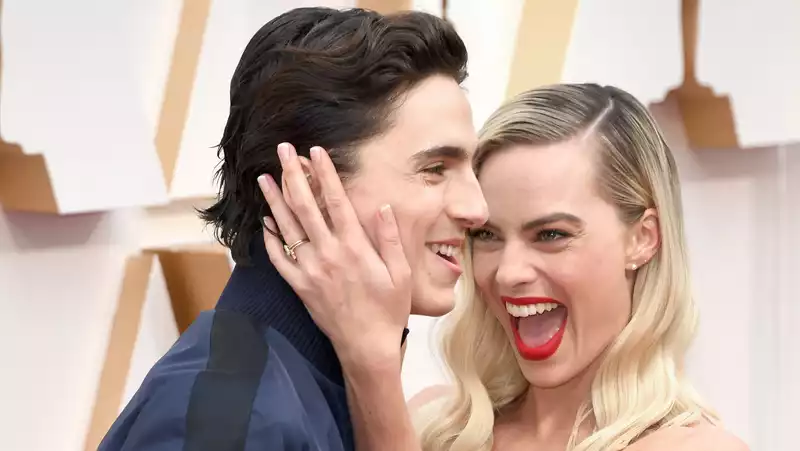 Timothée Chalamet photobombs Margot Robbie on the Oscars red carpet.