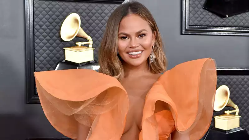 Chrissy Teigen plays "Luigi's Mansion 3" on set.