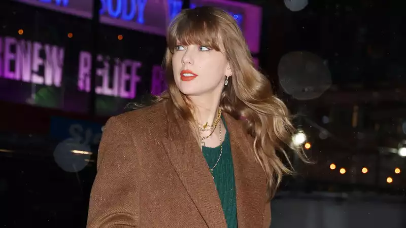 Taylor Swift's black knee-high boots are an essential part of the shoe trend.