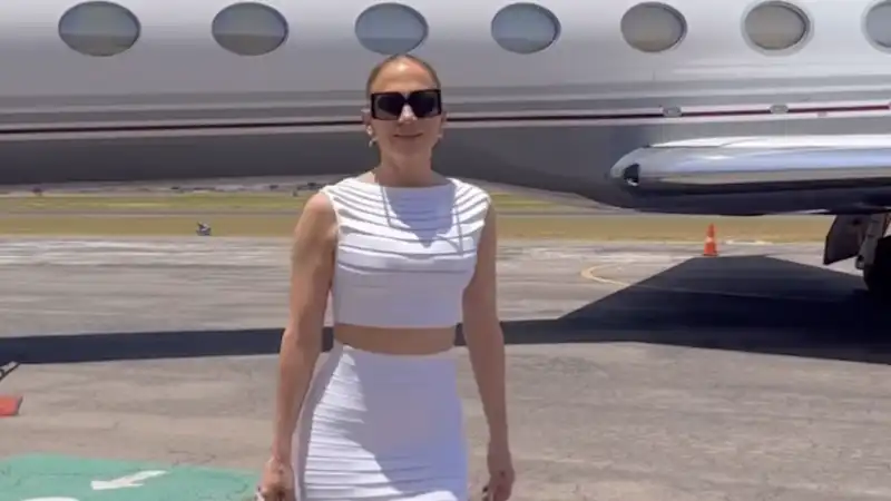 Jennifer Lopez's comfortable travel outfit includes an unusual Hermes Birkin bag and a white skirt set