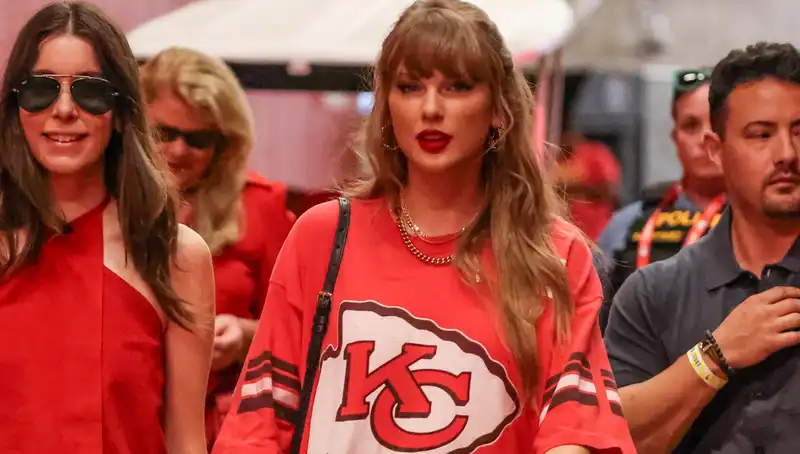 Taylor Swift wears an oversized Chiefs T-shirt like a mini dress and classic black boots.