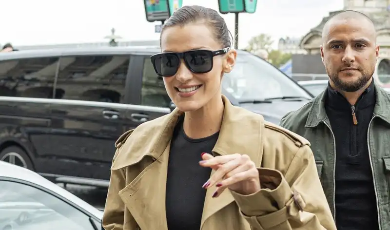 Bella Hadid shows off her effortless French girl staple style of trench coat and biker boots at Paris Fashion Week.