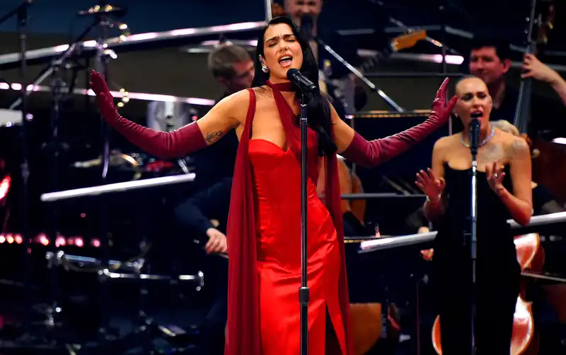 Dua Lipa in a cherry red corset gown and merlot cape for an intimate concert in London