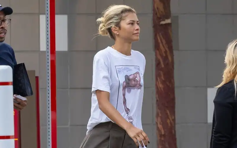 Zendaya wears a rare vintage T-shirt with boyish baggy pants and white sneakers