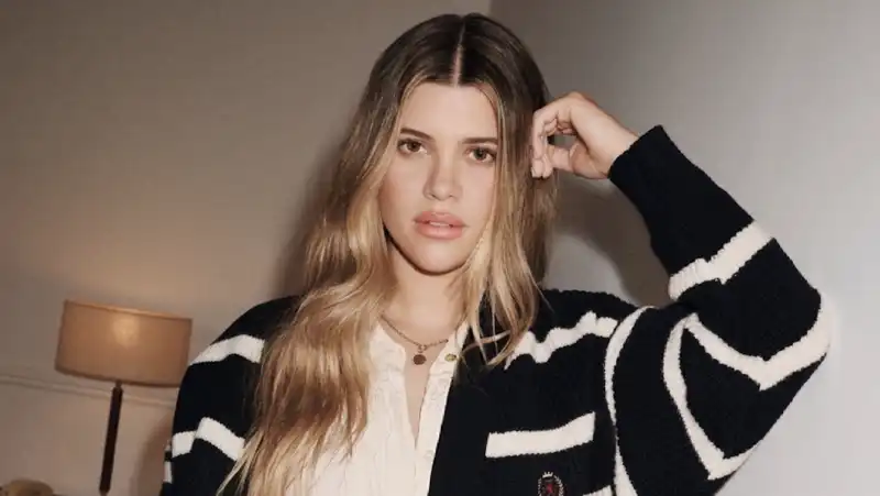 Sofia Richie updates her “rich girl uniform” with a preppy striped cardigan and $119 bag.