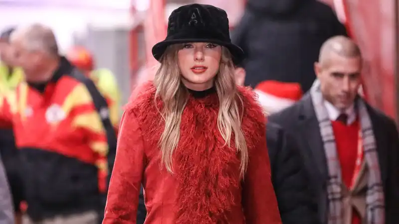 Taylor Swift wears her luxurious crimson fur coat like a mini dress for the Battle of the Chiefs